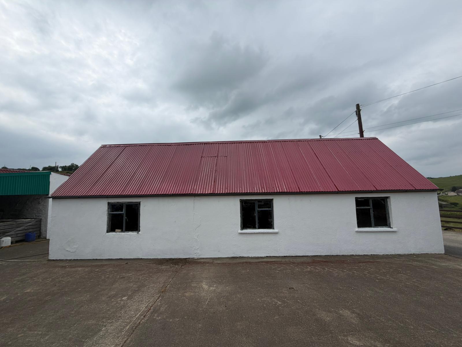 Farm building with freshly sprayed red tin roof