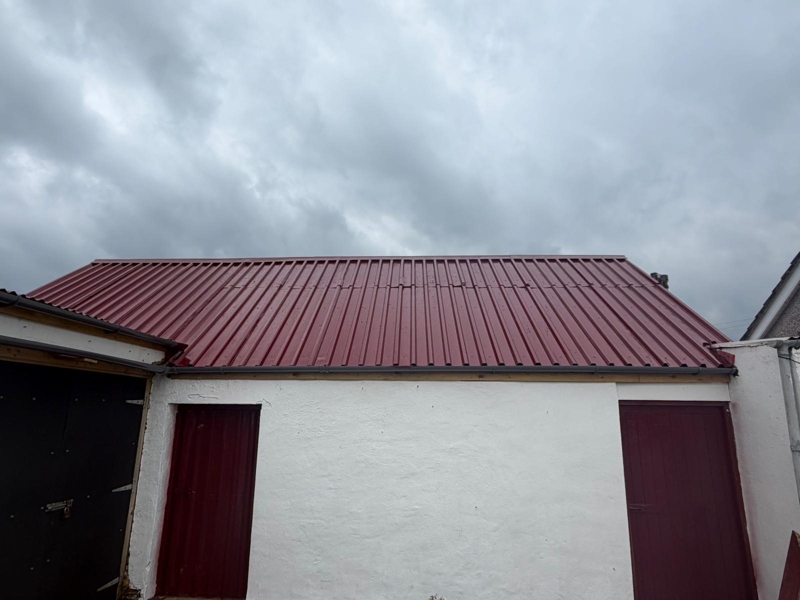 Freshly resprayed red corrugated tin roof on farm outbuilding